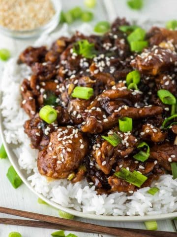close-up of pork tossed in sweet soy ginger garlic sauce on bed of white rice