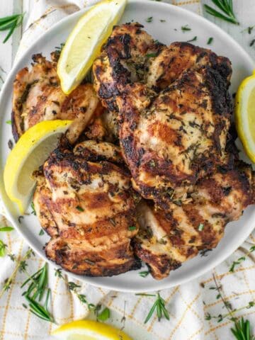 overhead shot of grilled lemon herb chicken on plate